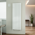 White vertical panel radiator with fins mounted on wall in a minimalist designer living room or hallway