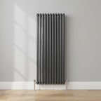 Anthracite vertical radiator in room setting with chrome angled floor valves